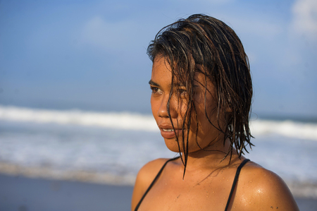 head and shoulders lifestyle portrait of young beautiful and sexy Asian girl in bikini with wet hair enjoying holidays at tropical beach posing cool smiling happy at the sea in exotic beauty conceptの写真素材