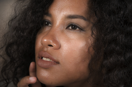 close up face portrait of young beautiful and exotic mixed ethnicity latin and afro American woman with expressive eyes in beauty conceptの写真素材