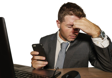young frustrated and stressed businessman in suit and tie working overwhelmed at office laptop...