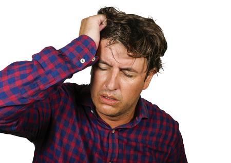 dramatic portrait of stressed and overwhelmed 30s or 40s white man holding head with hands in crazy stress and frustrated face expression looking to camera suffering problem isolated backgroundの写真素材