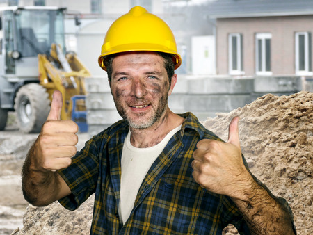 lifestyle portrait of young attractive and confident contractor or construction worker man with...