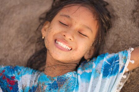 beach lifestyle portrait of young beautiful and happy Asian American mixed ethnicity child girl 7 or...