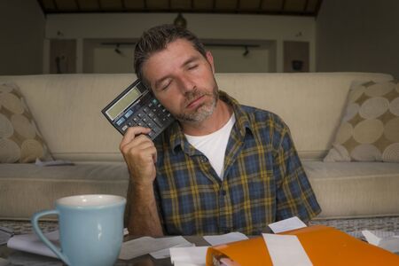 young attractive stressed and frustrated man at home living room couch doing domestic accounting...