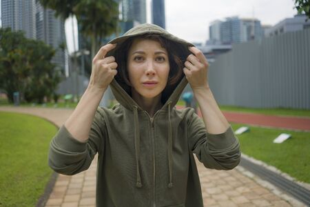 outdoors portrait of young attractive and active  jogger woman in hoodie top ready for morning...