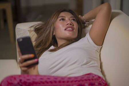 lifestyle portrait of young attractive happy and relaxed student girl enjoying homey at living room...