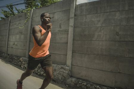 urban runner workout . Young attractive and athletic black African American man running outdoors on...