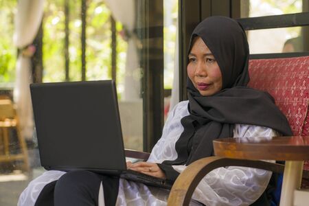 lifestyle portrait of middle age Asian Indonesian Muslim woman in traditional hijab head scarf...