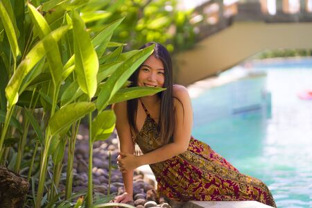 lifestyle portrait of young beautiful and happy Asian Chinese tourist woman smiling cheerful and natural enjoying Summer holiday getaway at luxury tropical resort in travel destination conceptの写真素材