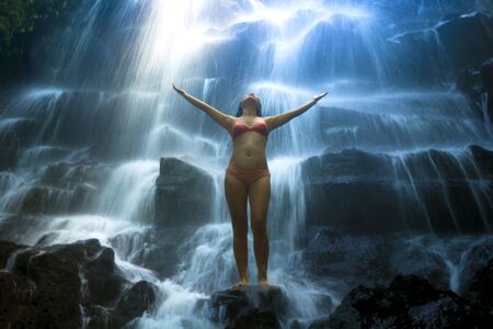 natural portrait of young beautiful and happy Asian Korean woman in bikini enjoying nature at...
