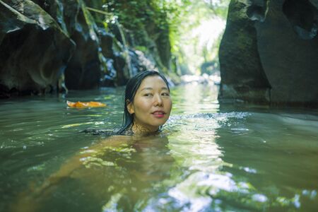 young beautiful and happy Asian Korean woman in bikini enjoying unique Summer holidays at tropical...
