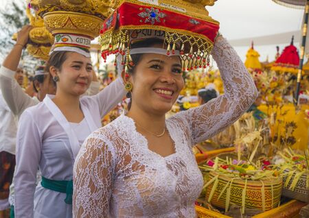 Bali / Indonesia - Sept 14th 2019 . Beautiful Balinese women carrying sacred offerings on their heads in traditional style dressed in delicate Indonesian Kebaya during traditional Hindu ceremonyのeditorial素材