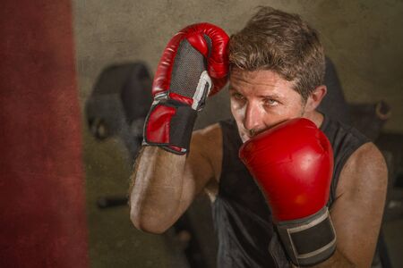 lifestyle gym workout portrait of attractive and fierce looking boxer man 30s to 40s in boxing...