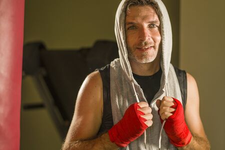 sport fitness lifestyle portrait of young happy and sweaty man boxing at gym working out sweaty in...