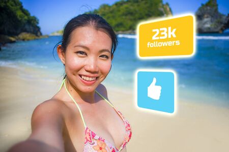 Successful Asian social media influencer girl taking selfie in the beach . young beautiful and happy...