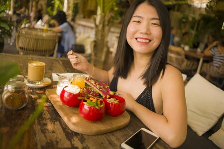 Veggie brunch . natural lifestyle portrait of young happy and beautiful Asian Korean woman eating...