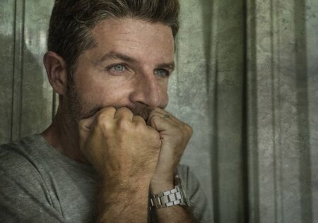 dramatic portrait of middle aged sad and depressed man in pain feeling stressed and frustrated...