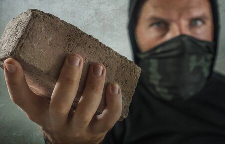 young man as fanatic and aggressive anarchist rioter . furious and scary violent anti-system...