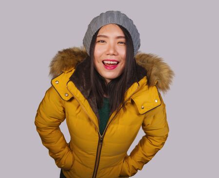 fashion isolated portrait of young beautiful and happy Asian Korean woman in Winter hat and warm...