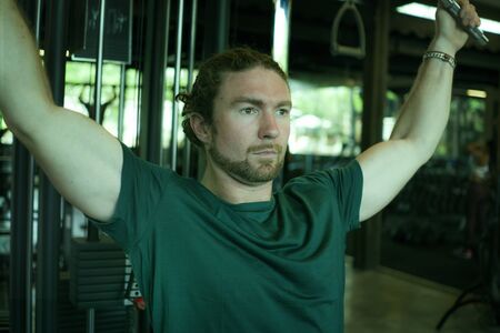 natural lifestyle portrait of young athletic and attractive man training and body building doing...