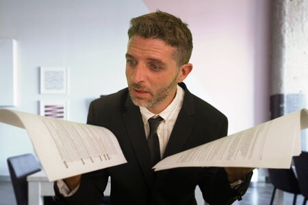 corporate business lifestyle portrait of stressed and frustrated businessman holding paperwork...