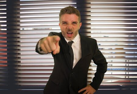 corporate business work lifestyle portrait of stressed and angry man screaming furious scolding very upset and unhappy as company boss in working problems and stress conceptの写真素材