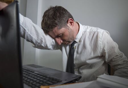 corporate business work stress - young desperate and frustrated businessman working stressed and...
