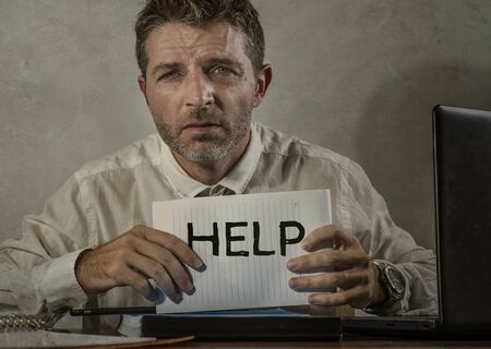 corporate business worker in stress - young attractive stressed and desperate businessman holding...
