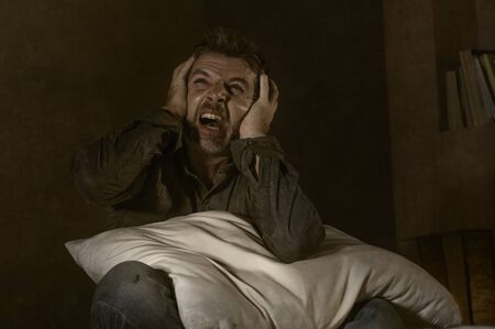 dramatic portrait of depressed and sick man suffering from psychosis illness or mental disorder looking weird and helpless in psychiatric and psychological problem conceptの写真素材