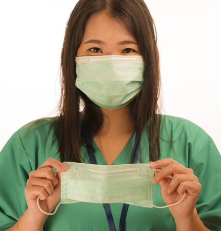 Coronavirus outbreak - young beautiful Asian Chinese medicine doctor woman or hospital nurse recommend use of protective face mask in prevention vs virus infection in health careの写真素材