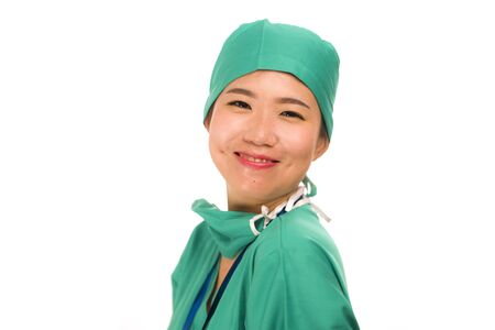 Asian Chinese woman as successful physician - young beautiful and happy medicine doctor or chief hospital nurse in green scrubs and surgeon hat smiling confident in health care conceptの写真素材