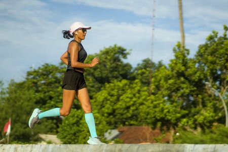 outdoors fitness portrait of young attractive and athletic woman jogging happy on city park doing...