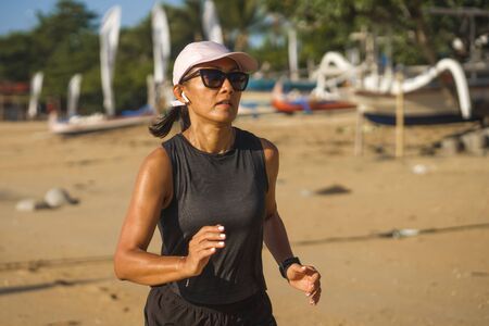 outdoors fitness lifestyle portrait of young attractive and athletic woman in compression running socks jogging on the beach doing intervals workout in athlete training concept and healthy lifestyleの写真素材