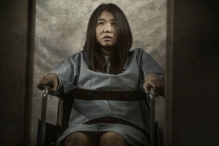 insanity asylum horror movie style portrait of young sick and psychotic Asian Chinese woman isolated...