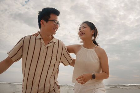 sweet and romantic lifestyle portrait of young Asian Korean couple in love enjoying holiday on...