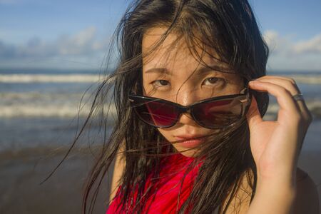outdoors lifestyle portrait of young beautiful and happy Asian Japanese woman in sunglasses wearing...