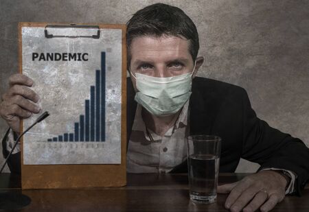 health organization executive man in medical face mask giving information at press conference about virus outbreak showing clipboard with epidemic disease spread warning about pandemicの写真素材