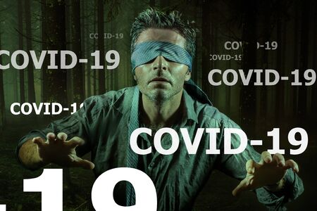 covid-19 virus outbreak conceptual image on young scared and blindfolded man lost in the dark and...
