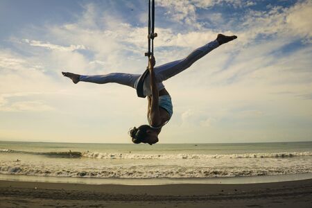 acro yoga meditation beach workout  isolated on blue sky - silhouette of young attractive and...
