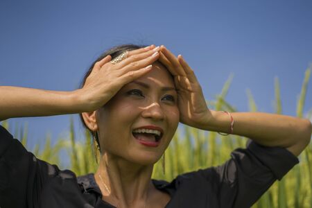 outdoors portrait of attractive and happy Asian Korean woman 40s or 50s enjoying nature excited and carefree playful at tropical rice field during Summer holidays tourist travelの写真素材