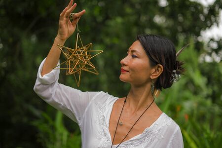 mind and body connection - beautiful and happy healer Asian woman holding incense cup doing ritual...
