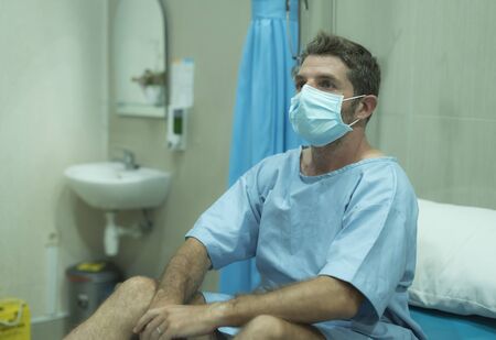 attractive and scared man infected by covid-19 - dramatic portrait of adult male in face mask...