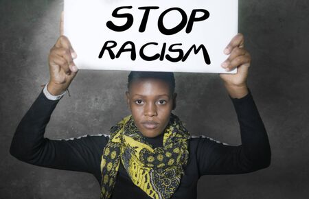 stop racism black activist girl protesting against government - young outraged and hipster African  woman showing protest banner demanding stop racial discriminationの写真素材