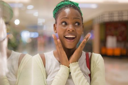 young beautiful and happy afro American girl at buying shopping mall - lifestyle portrait of millennial black girl enjoying looking  clothing at beauty fashion store smiling cheerfulの写真素材
