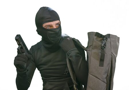 thief at work - criminal man in black covered with balaclava mask holding unlocked padlock at...