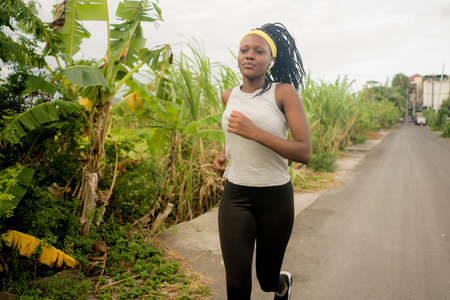 young black  runner girl enjoying outdoors jogging workout - young attractive and fit African...