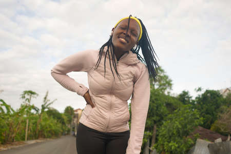 runner girl lifestyle portrait - young attractive and fit black afro American woman looking away...
