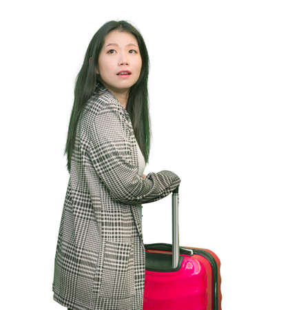 young happy and beautiful Asian Korean woman carrying tourist suitcase ready for holidays trip cheerful and excited isolated on white backgroundの写真素材