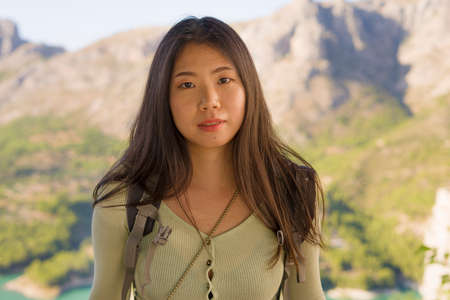 young happy and attractive Asian Korean tourist woman hiking and enjoying beautiful mountain view during Summer holidays travel in tourism conceptの写真素材
