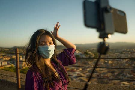 young happy and beautiful Asian Korean woman outdoors at viewpoint balcony enjoying sunset view of Spain town during Europe holiday travel feeling free and relaxedの写真素材