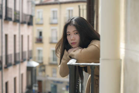 dramatic portrait of young beautiful sad and depressed Asian Chinese woman feeling unhappy and worried suffering some problem going through depression and anxiety crisisの写真素材